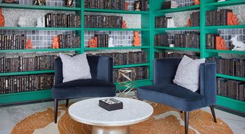 two chairs and a table in front of a library